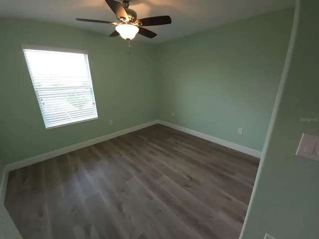 an empty room with a window and a fan