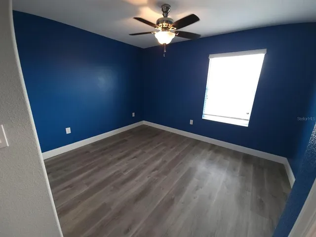 en empty room with windows and fan