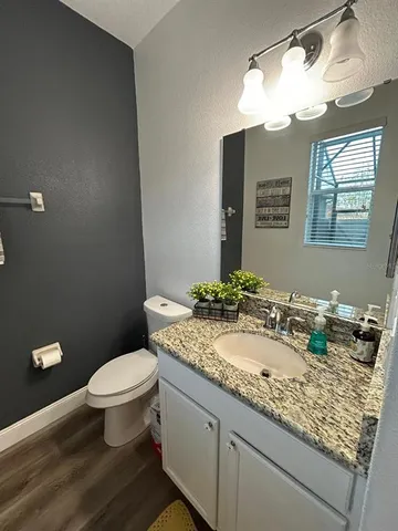 a bathroom with a granite countertop toilet sink and mirror