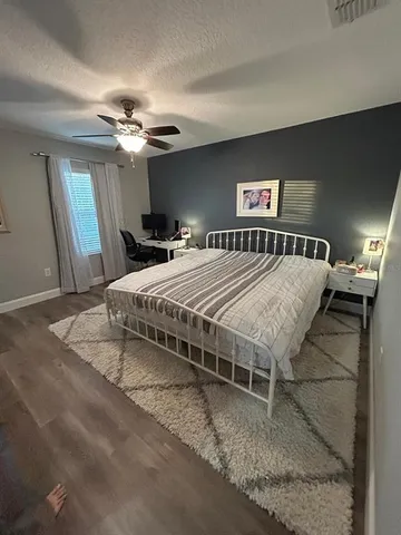 a bedroom with a large bed chandelier and a window