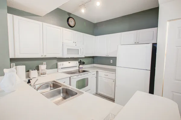 a kitchen with appliances a sink and cabinets