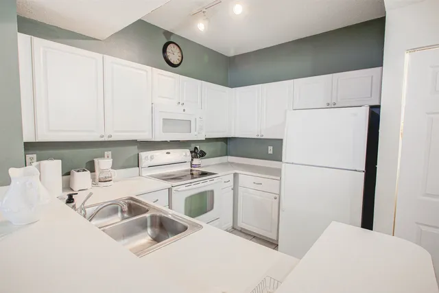 a kitchen with appliances a sink and cabinets
