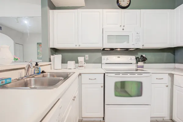 a kitchen with cabinets appliances a sink and a counter top