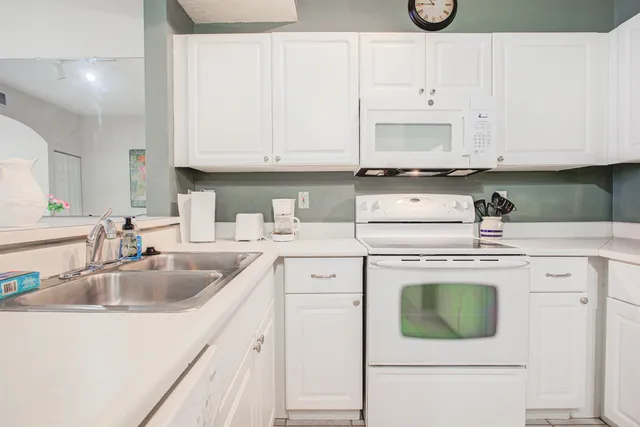 a kitchen with cabinets appliances a sink and a counter top