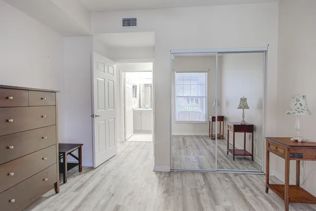 a view of a hallway with wooden floor and cabinet