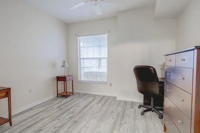 a view of a workspace with furniture and a window