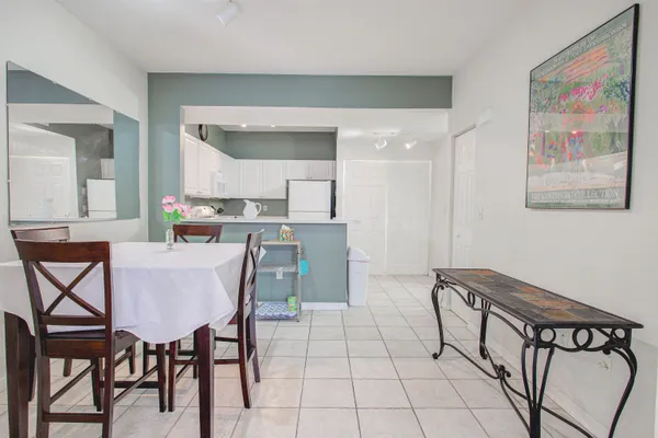 a dining hall with stainless steel appliances kitchen island granite countertop a dining table and chairs