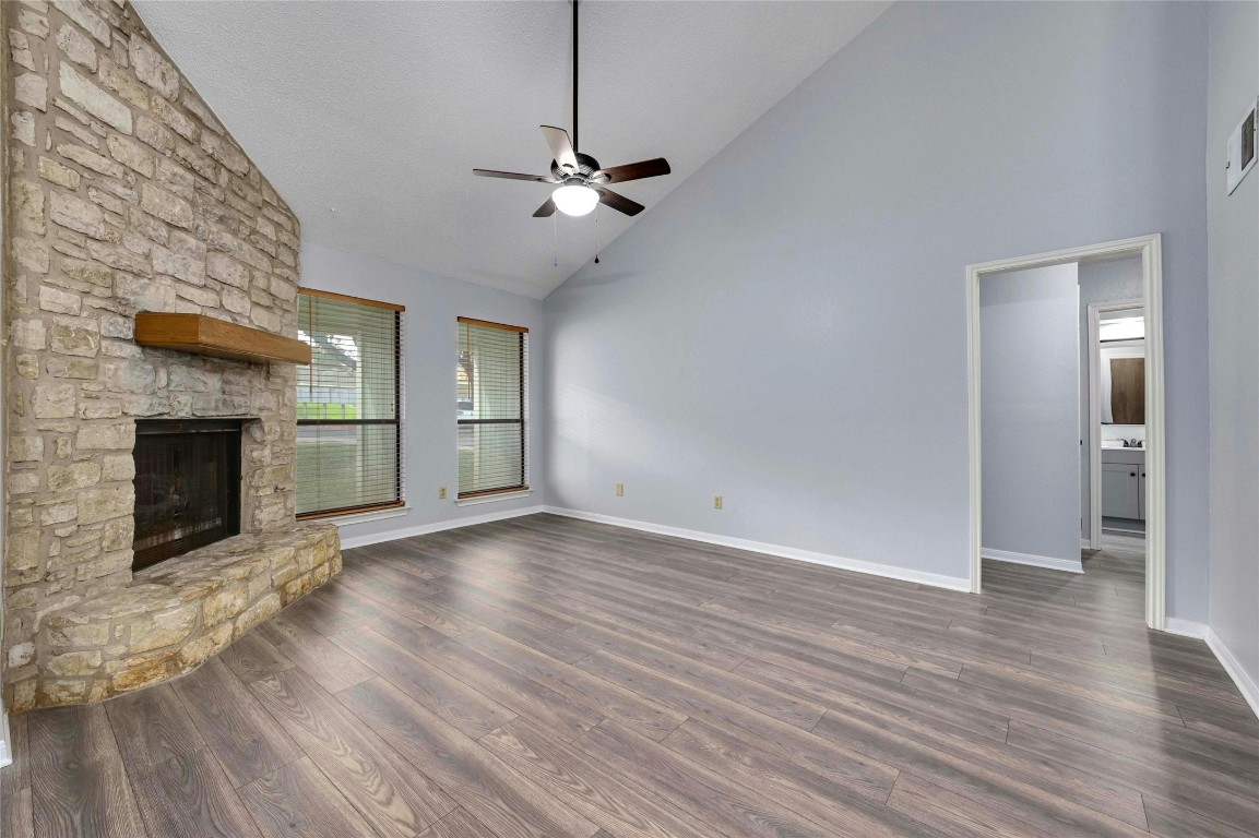 wooden floor fireplace and windows in an empty room