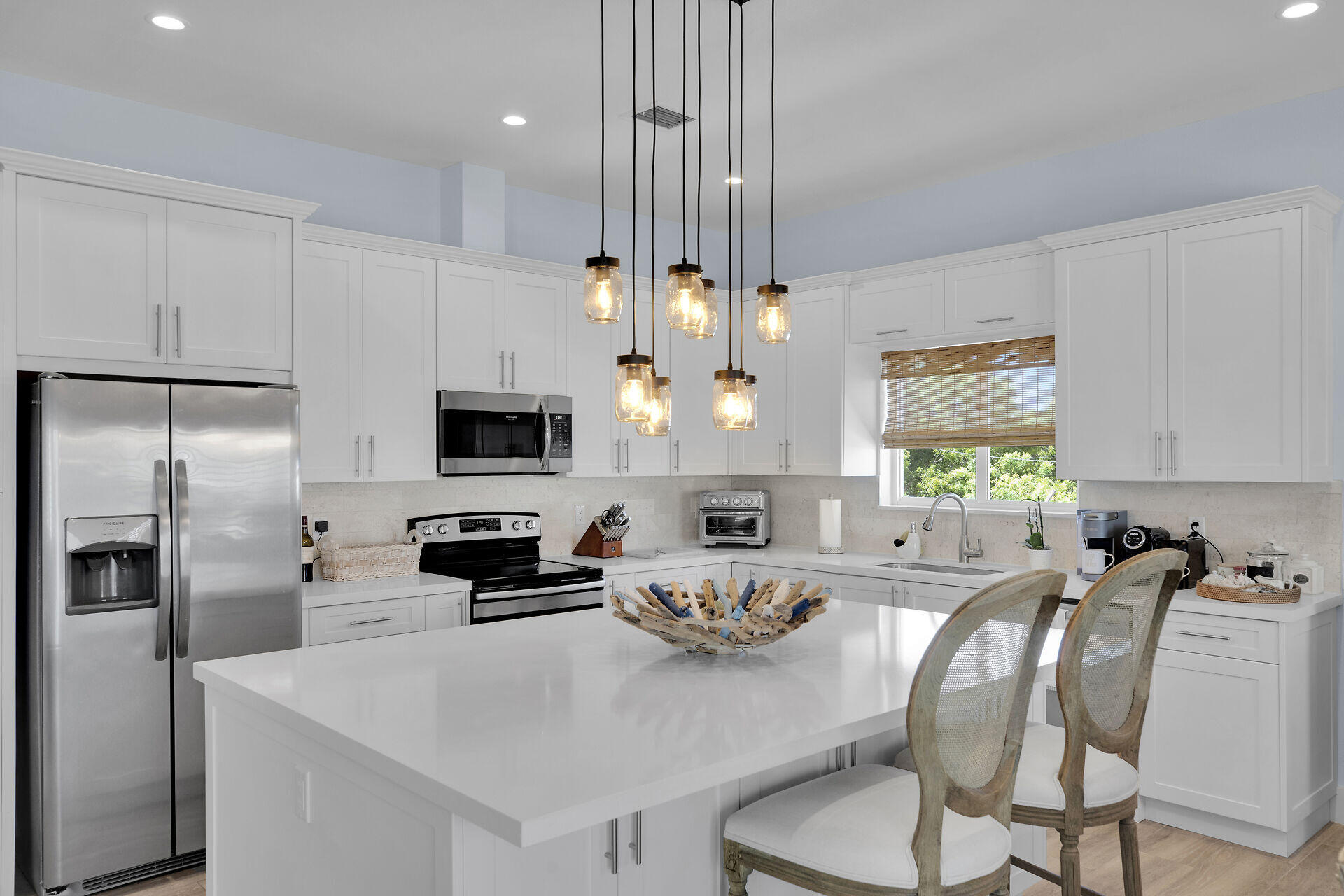 162 Marina Avenue Key Largo, FL 33037 - Photo 15 of 53 a kitchen with stainless steel appliances a microwave a stove a refrigerator a sink a dining table and chairs