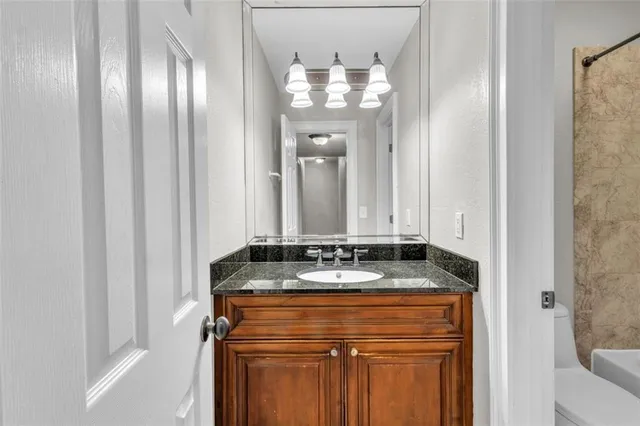 a bathroom with a granite countertop sink and a mirror