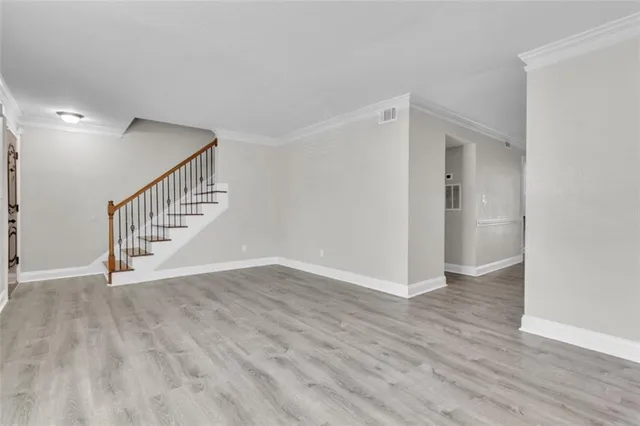 a view of an empty room with wooden floor