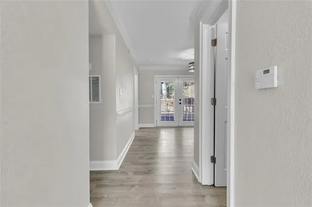 a view of a hallway with wooden floor and a living room