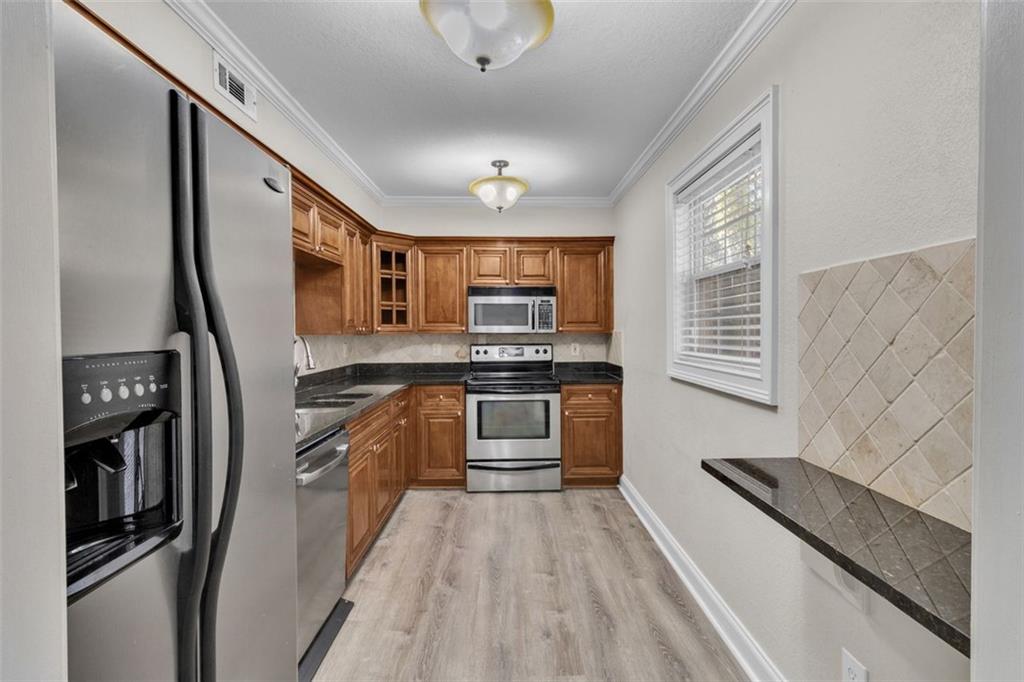 4430 Tilly Mill Road, Unit 206 Atlanta, GA 30360 - Photo 10 of 29 a kitchen with stainless steel appliances granite countertop a refrigerator a stove and a sink with wooden floor