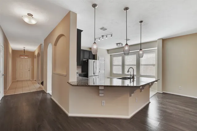 a large kitchen with a sink and dishwasher with granite countertop