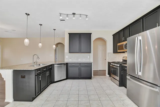 a kitchen with stainless steel appliances a refrigerator stove and microwave