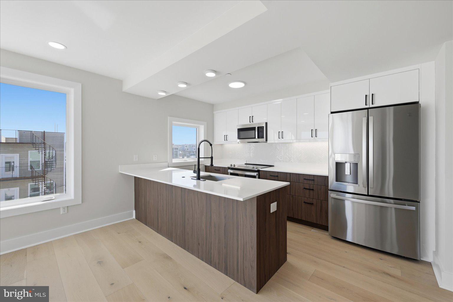 919 12th Street Northeast, Unit 404 Washington, DC 20002 - Photo 7 of 17 a kitchen with stainless steel appliances granite countertop a refrigerator a sink dishwasher a stove and a refrigerator
