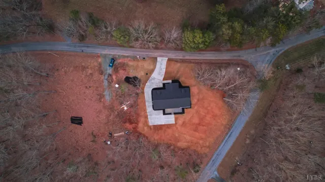 an empty room with wooden floor fireplace and windows