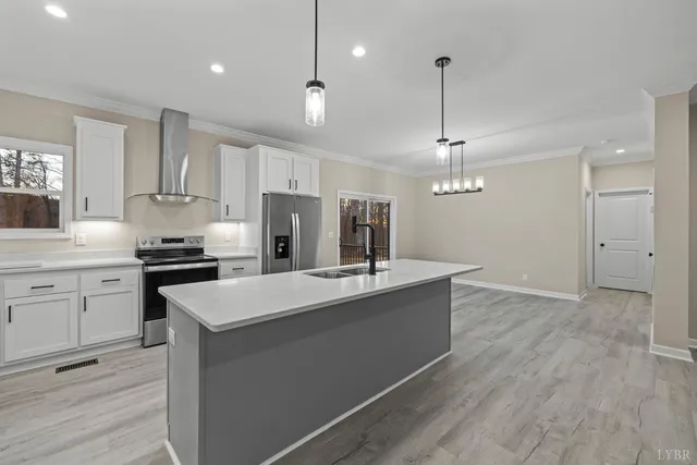 a kitchen with kitchen island white cabinets and stainless steel appliances