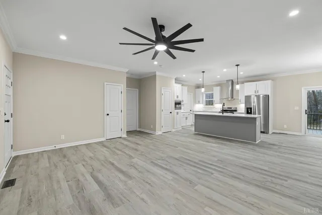 a kitchen with stainless steel appliances granite countertop a sink a stove a refrigerator and island with wooden floor