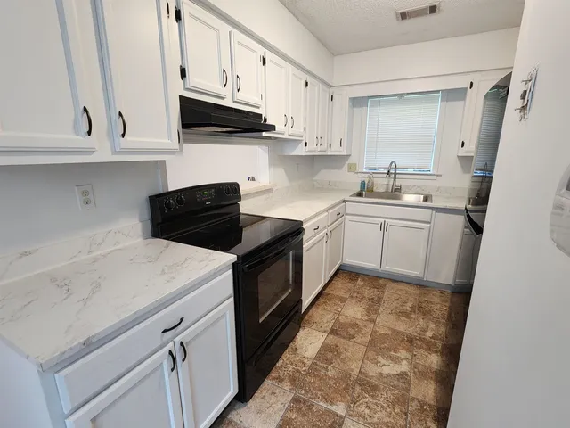 a kitchen with white cabinets and white appliances