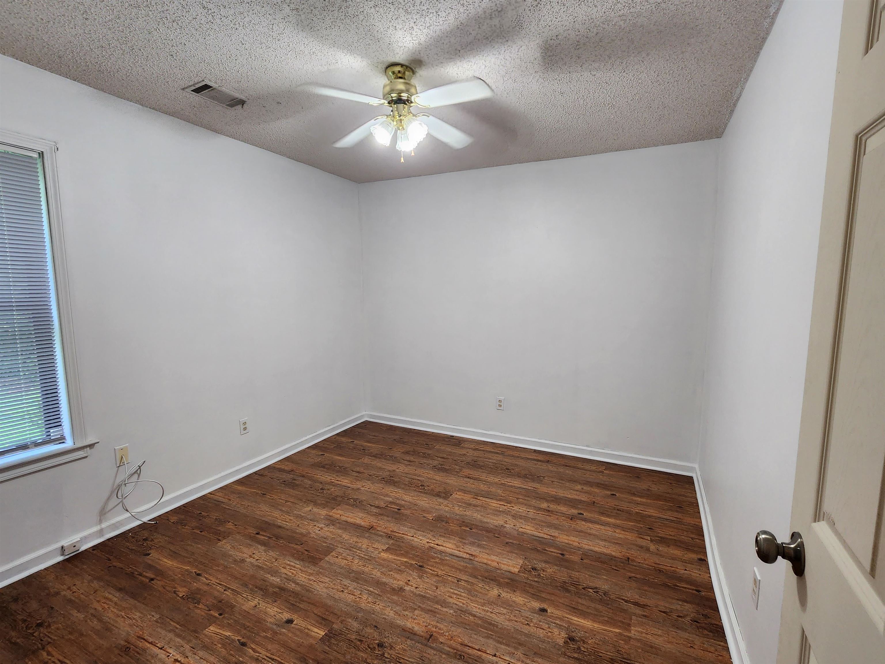 8186 Valley Ridge Trail Cordova, TN 38016 - Photo 10 of 13 an empty room with a chandelier fan and wooden floor