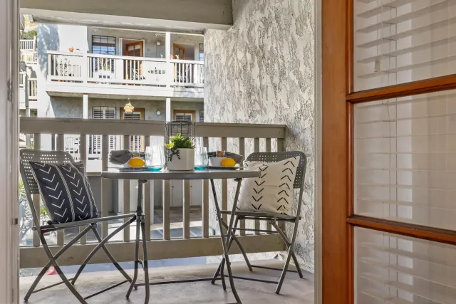 a view of a chairs and table in the balcony