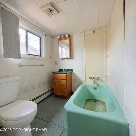 a bathroom with a sink toilet and window