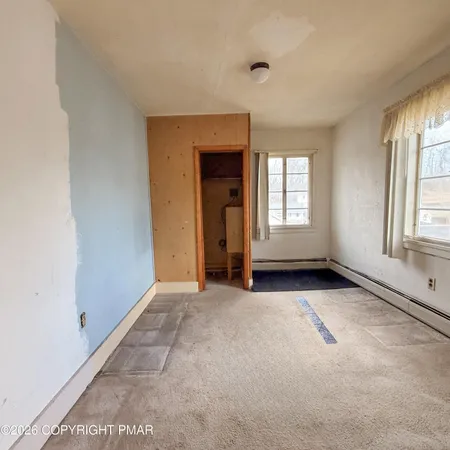 an empty room with windows and closet