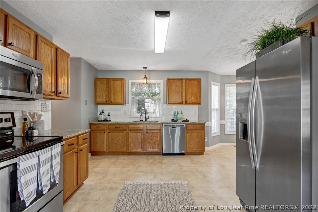 5823 Spreading Branch Road Hope Mills, NC 28348 - Photo 15 of 49 a kitchen with a refrigerator and a stove top oven