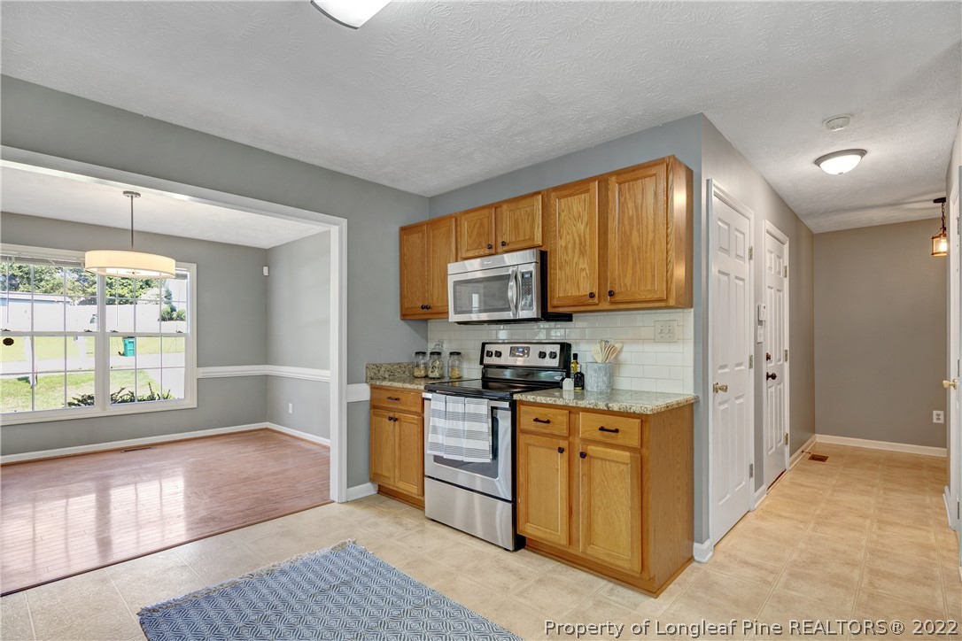 5823 Spreading Branch Road Hope Mills, NC 28348 - Photo 18 of 49 a kitchen with stainless steel appliances granite countertop a refrigerator and a stove top oven