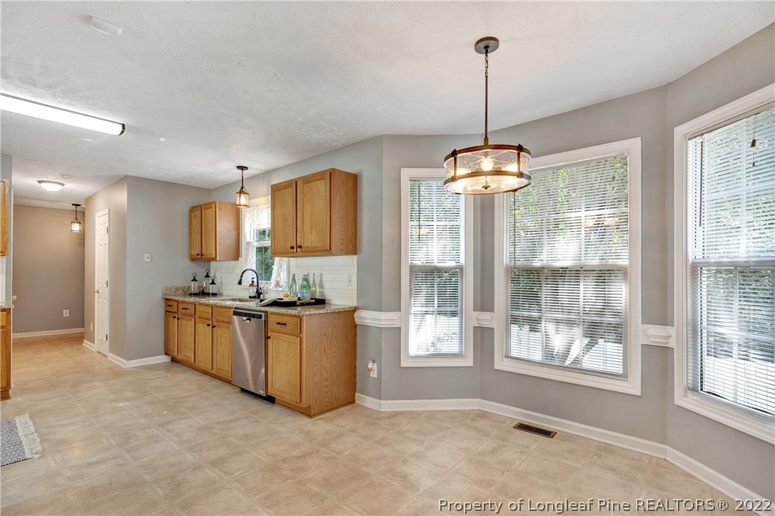 5823 Spreading Branch Road Hope Mills, NC 28348 - Photo 20 of 49 a kitchen with stainless steel appliances granite countertop a stove top oven and sink