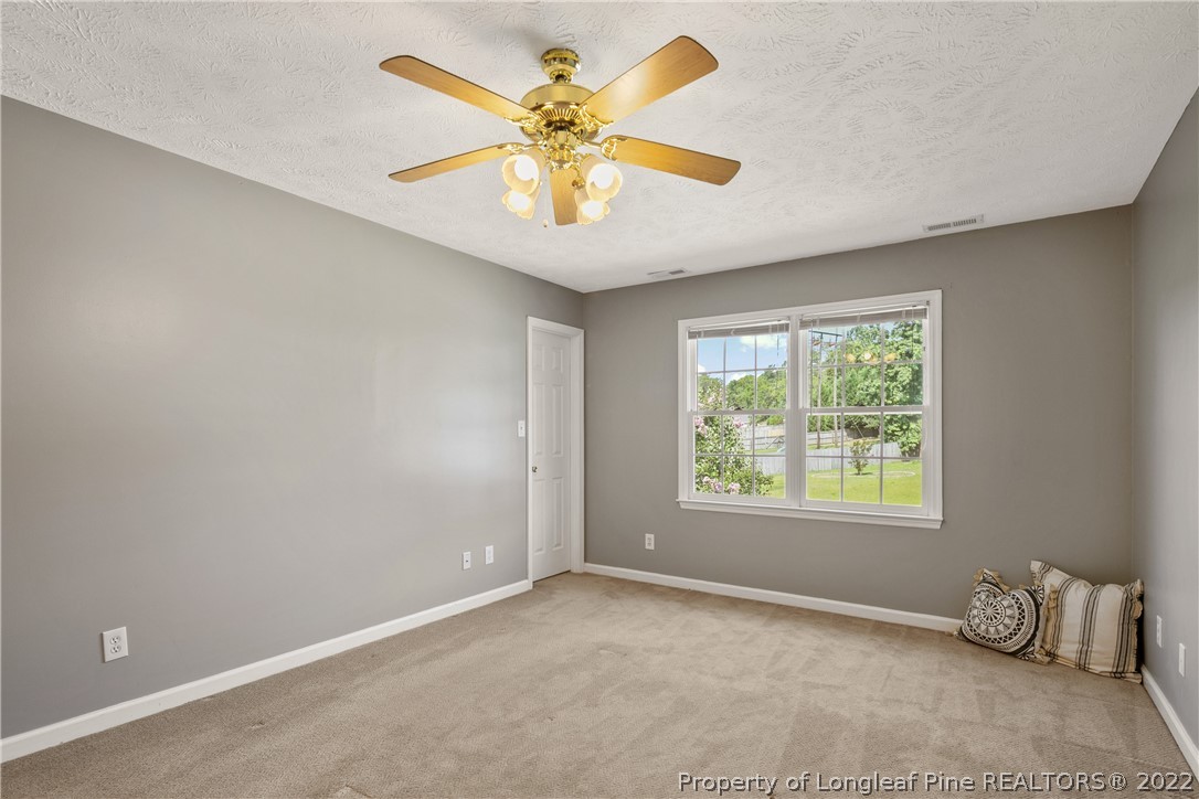 5823 Spreading Branch Road Hope Mills, NC 28348 - Photo 27 of 49 an empty room with windows and ceiling fan