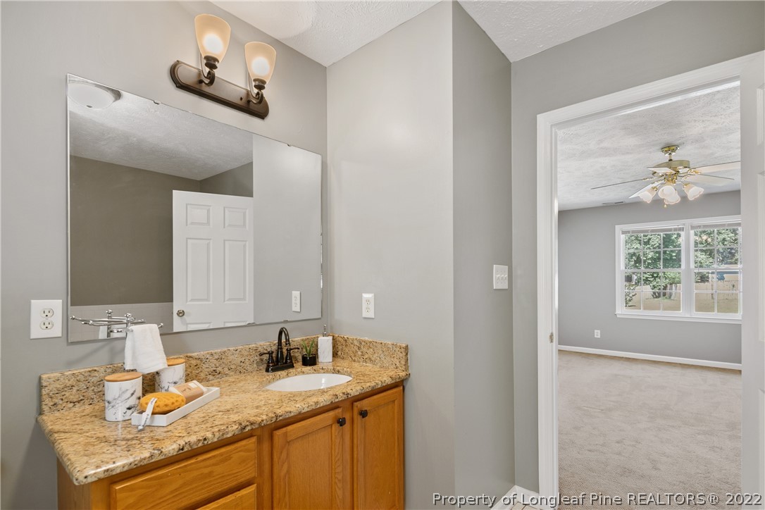 5823 Spreading Branch Road Hope Mills, NC 28348 - Photo 29 of 49 a bathroom with a granite countertop sink a mirror and window