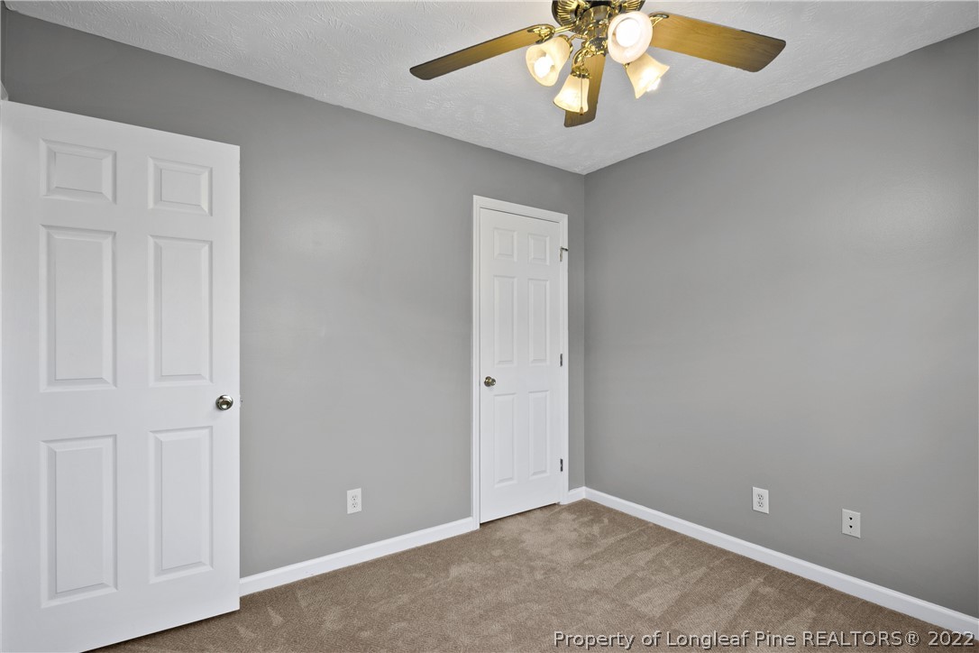 5823 Spreading Branch Road Hope Mills, NC 28348 - Photo 39 of 49 an empty room with closet and a chandelier fan