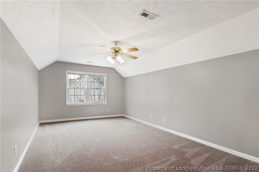 5823 Spreading Branch Road Hope Mills, NC 28348 - Photo 40 of 49 an empty room with windows and chandelier fan