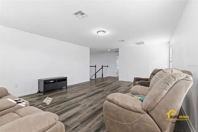 a bedroom with a bed and a flat tv screen on dresser