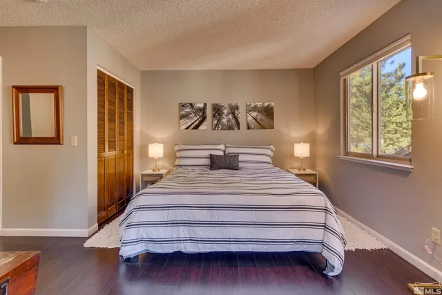 a spacious bedroom with a bed and wooden floor