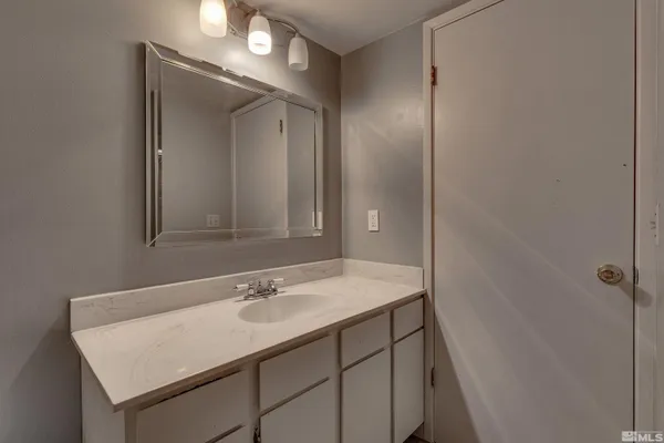 a bathroom with a sink vanity and a mirror