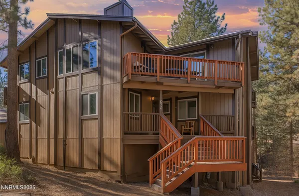 a view of a house with wooden deck and furniture