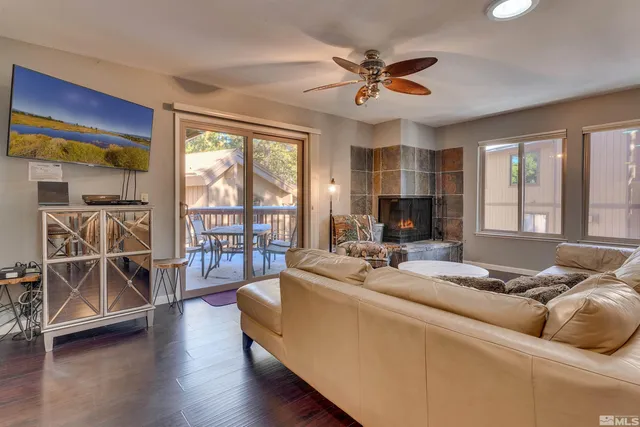 a living room with furniture and a flat screen tv with wooden floor