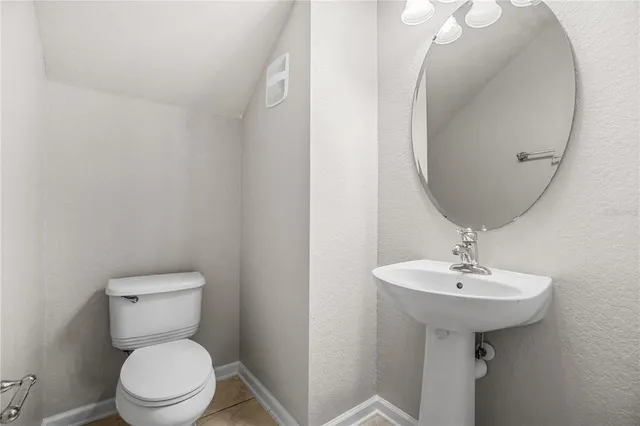 a bathroom with a toilet a sink and a mirror