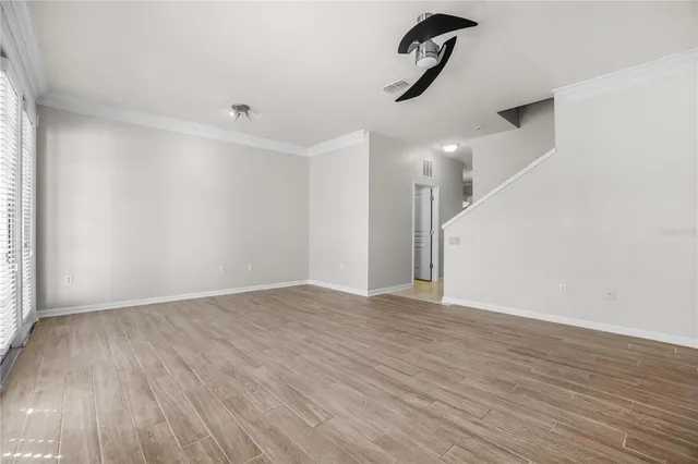 a view of an empty room with wooden floor