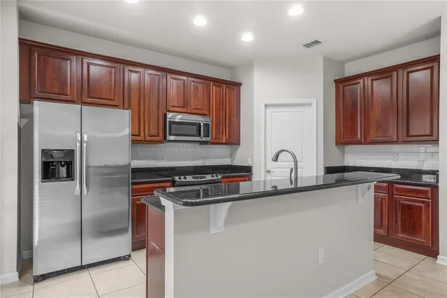 a kitchen with stainless steel appliances granite countertop a refrigerator sink and cabinets