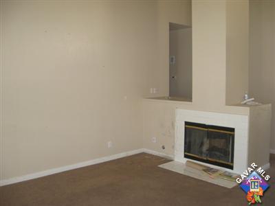 11544 Spring Street Adelanto, CA 92301 - Photo 8 of 15 an empty room with a fireplace