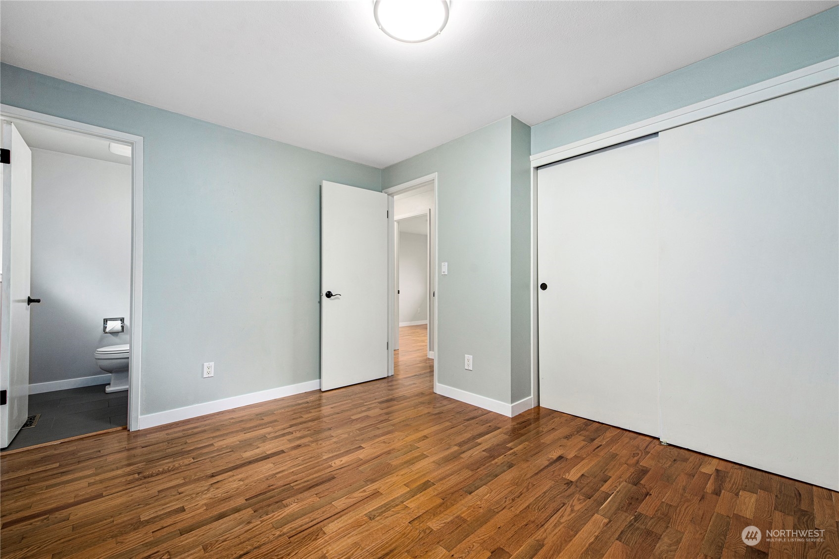 10209 Northeast 198th Street Bothell, WA 98011 - Photo 11 of 28 a view of an empty room with wooden floor and a bathroom