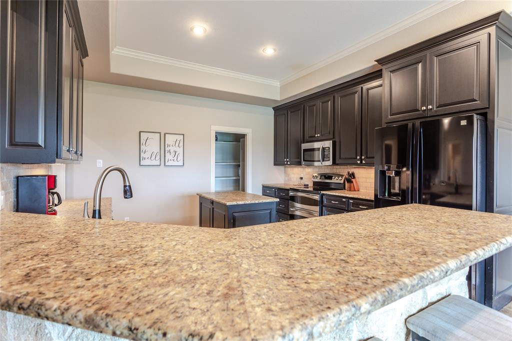 313 Wolf Creek Road Lorena, TX 76655 - Photo 10 of 39 a kitchen with stainless steel appliances granite countertop a stove refrigerator sink and cabinets