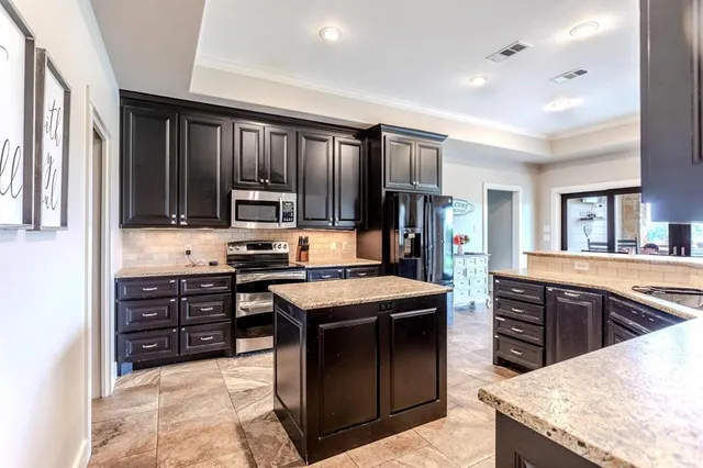 a kitchen with granite countertop a sink a stove and cabinets