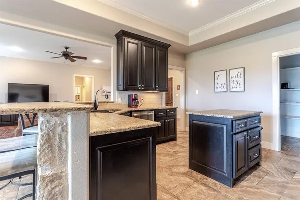 a kitchen with stainless steel appliances granite countertop a stove top oven a sink dishwasher a dining table and chairs with wooden floor