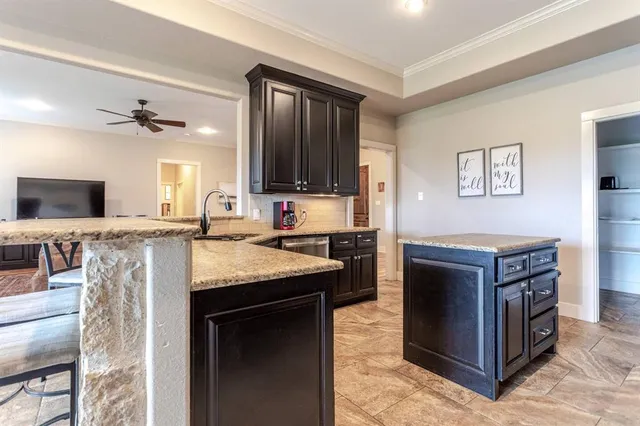 a kitchen with stainless steel appliances granite countertop a stove top oven a sink dishwasher a dining table and chairs with wooden floor