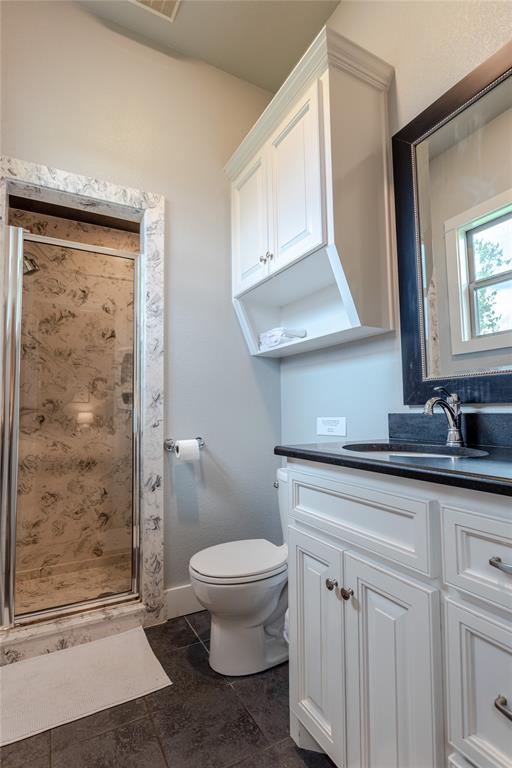 313 Wolf Creek Road Lorena, TX 76655 - Photo 25 of 39 a bathroom with a granite countertop sink a toilet a mirror and shower